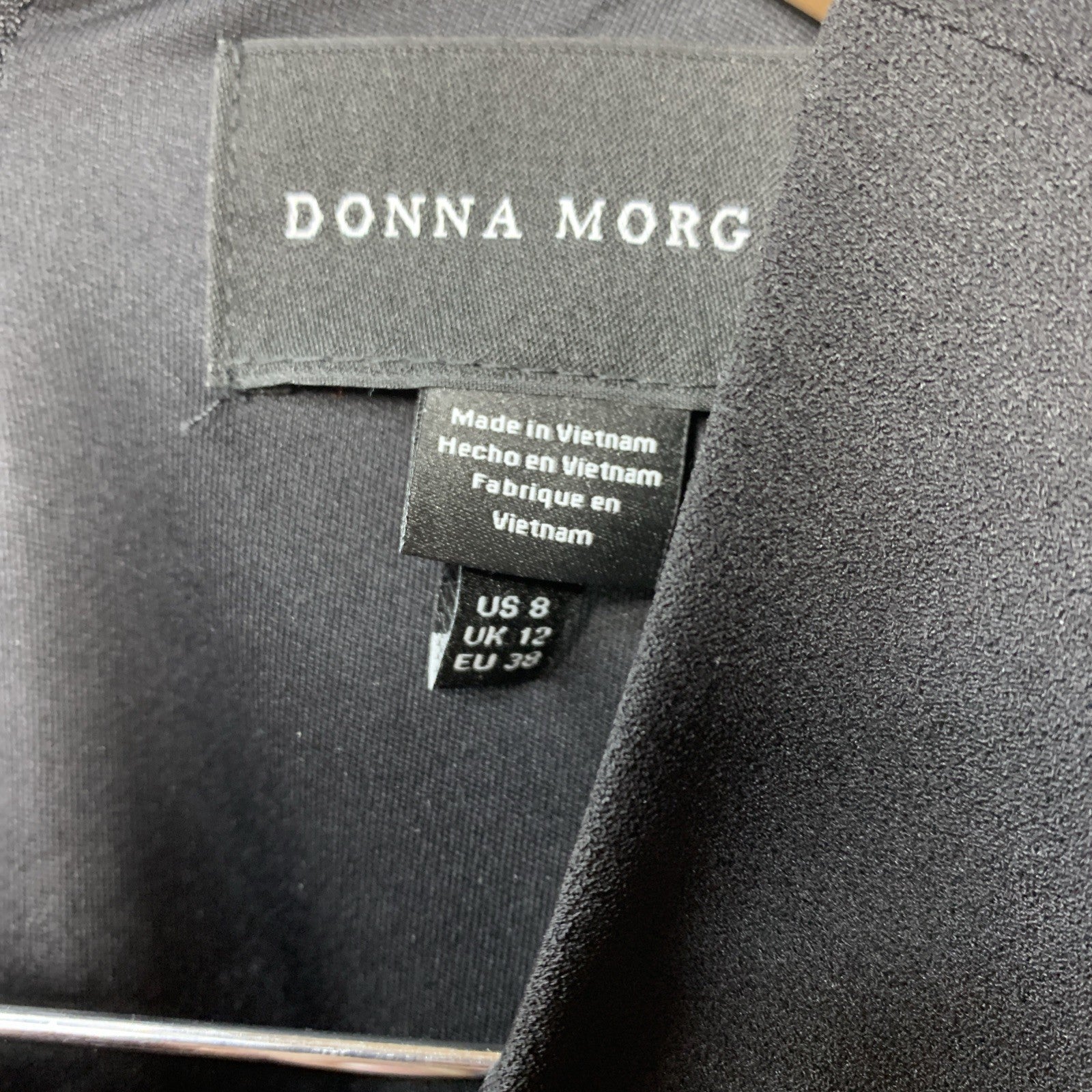 Black Donna Morgan sleeveless evening dress with asymmetrical cutout and high slit, size 8, featuring elegant design and flowing fabric.