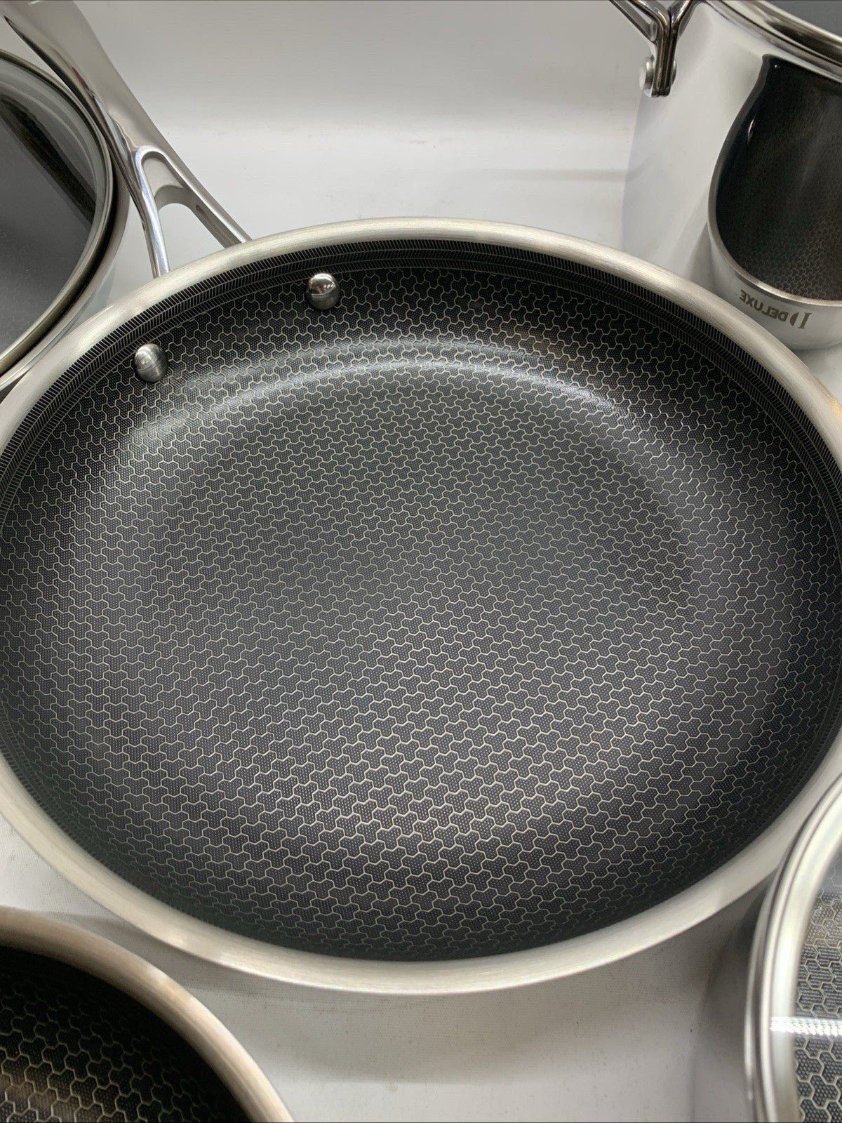 Deluxe 13-piece hybrid ceramic nonstick stainless steel cookware set by The Family Flips, including various pots and pans for kitchen use.