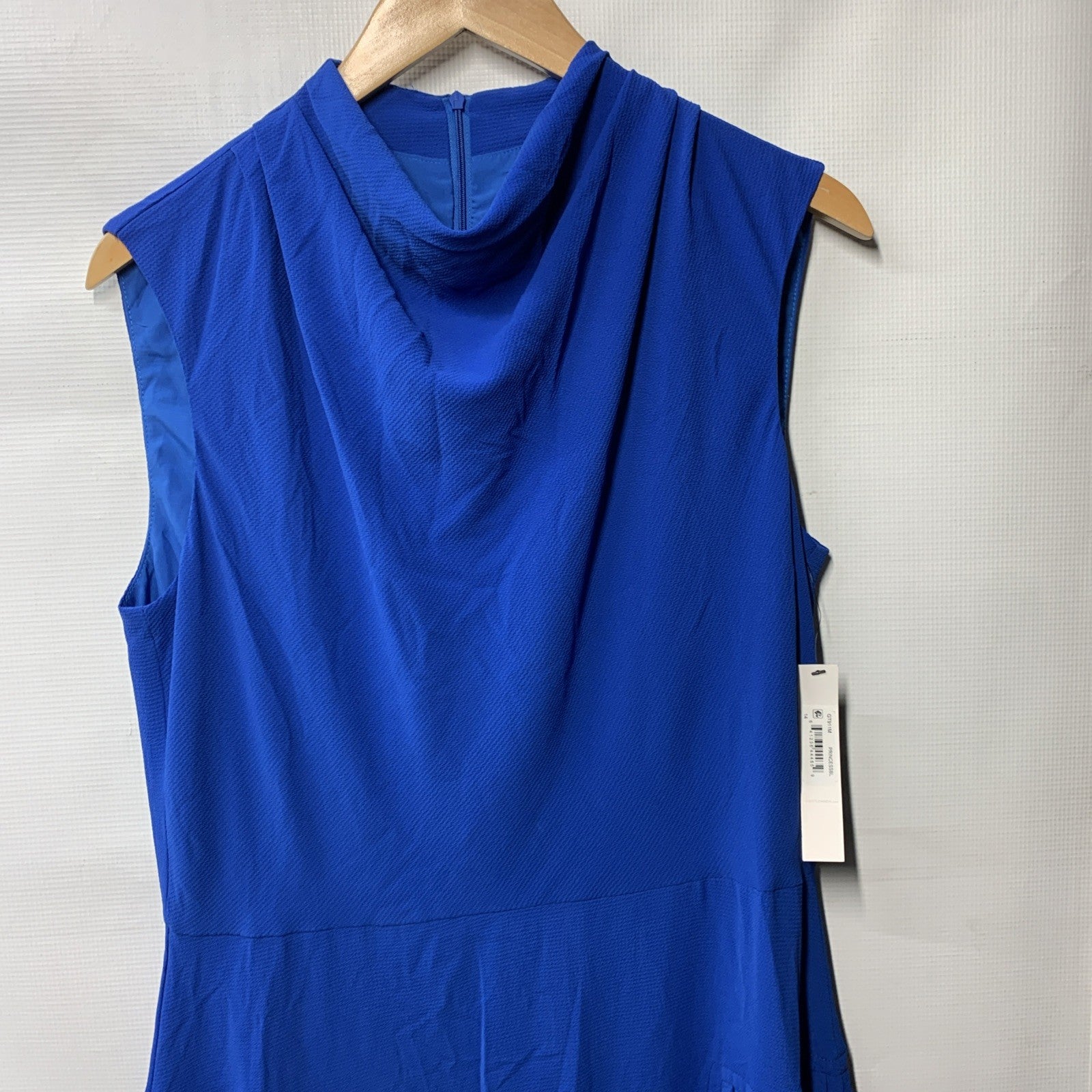 Black sleeveless cowl neck dress by The Family Flips featuring a fluted skirt, size 14, styled on a woman.